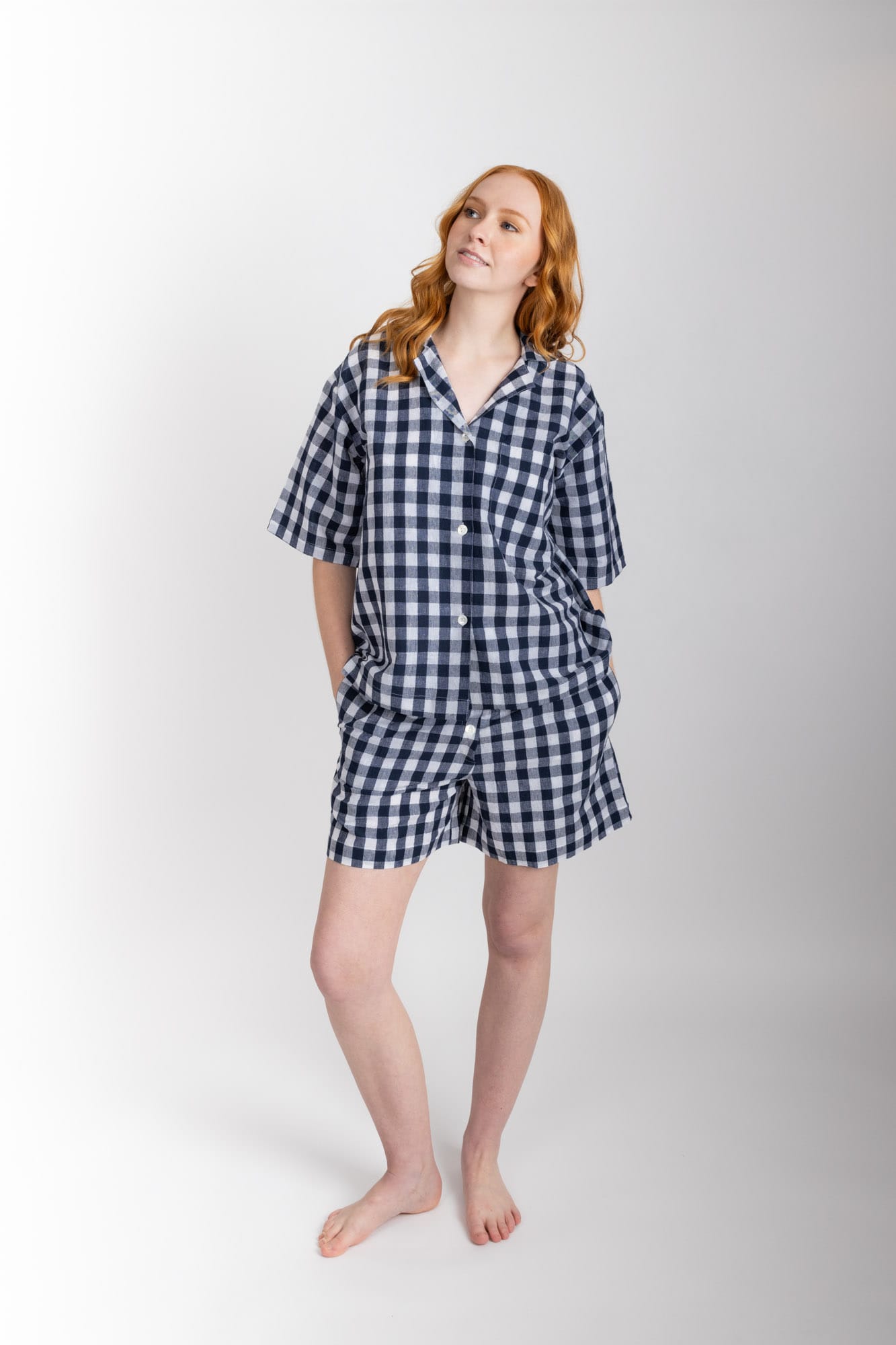 Women’s pyjama set including a short sleeve shirt and shorts. Made from an organic cotton and linen blend, in Navy check.  The shirt has shell buttons, a front pocket and a back pleat with locker loop detail.  The shorts feature natural shell buttons and an elasticated waistband for comfort.