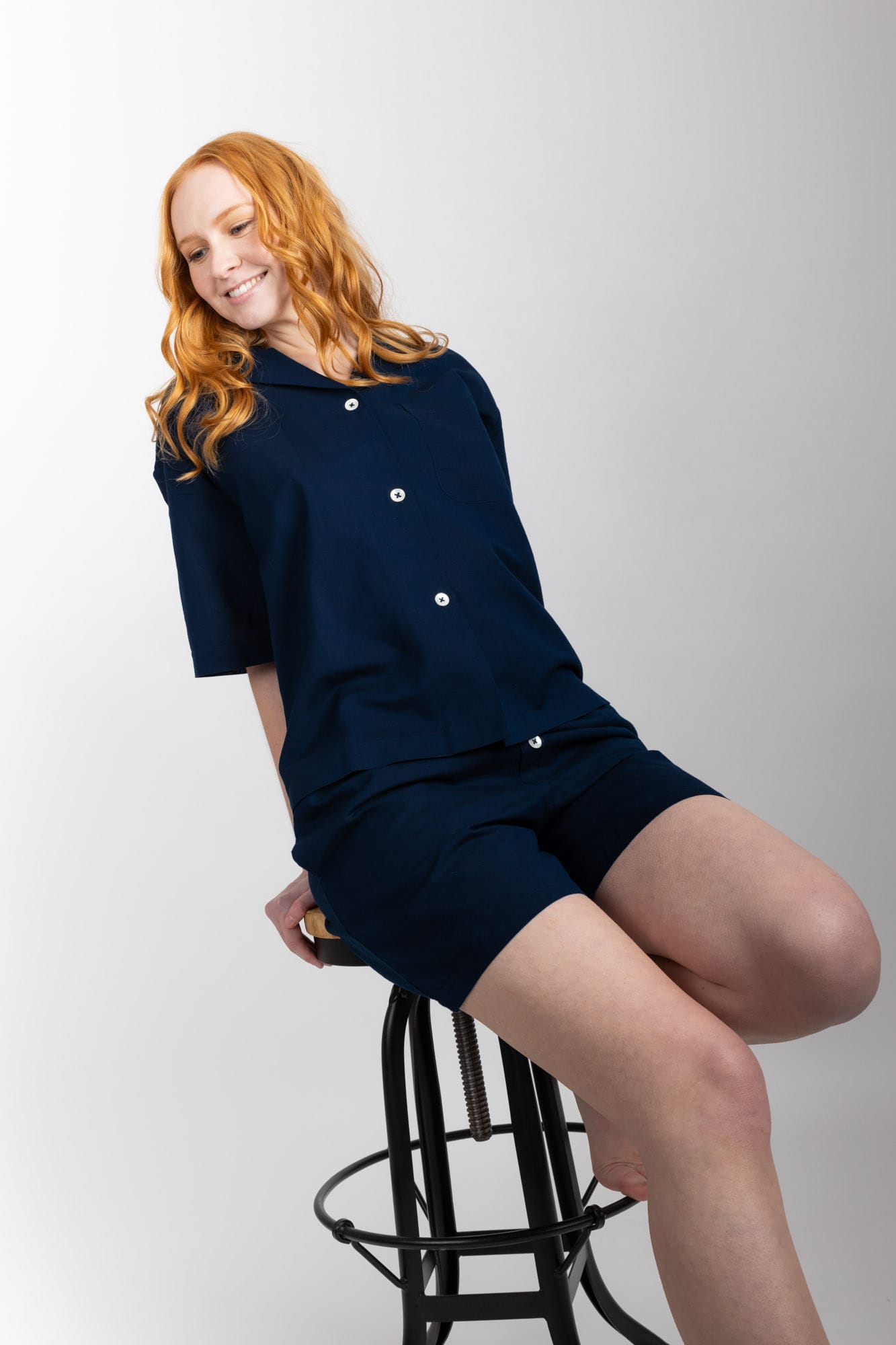 Women’s pyjama set including a short sleeve shirt and shorts. Made from an organic cotton and linen blend, in Navy.  The shirt has shell buttons, a front pocket and a back pleat with locker loop detail.  The shorts feature natural shell buttons and an elasticated waistband for comfort.