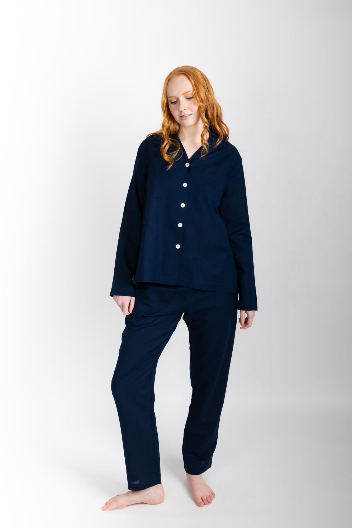 Women’s pyjama set including a long sleeve shirt and long sleeve pants. Made from an organic cotton and linen blend, in Navy.  The shirt has shell buttons, a front pocket and a back pleat.  The pants feature an elasticated waistband for comfort.