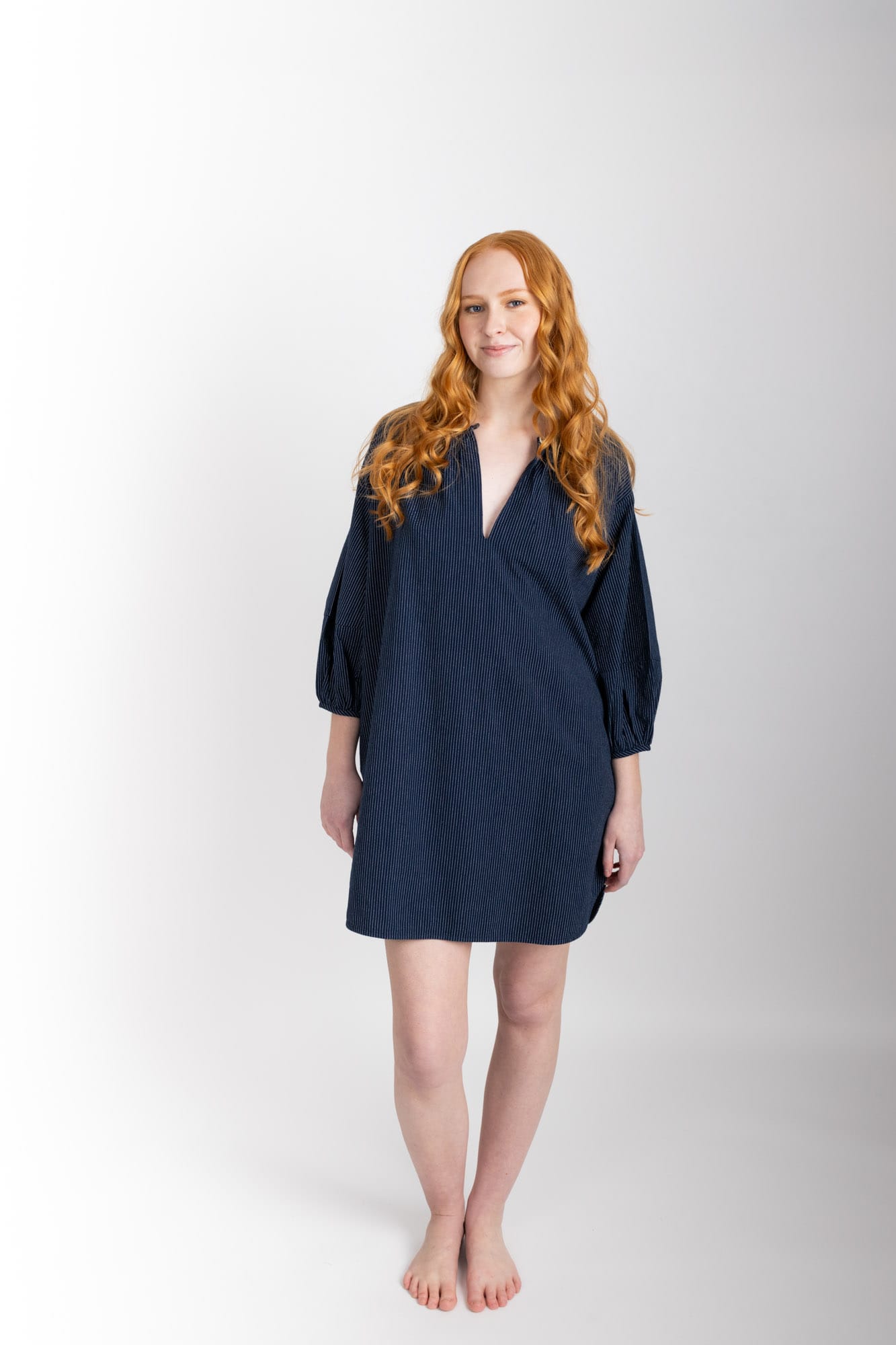 This knee length women’s nightdress dress has a relaxed fit with gathered sleeves ,and a single loop buttoned neckline which opens to a V-neck. In navy pinstripe and made from 100% organic cotton, it features deep pockets, and is finished with French seams.