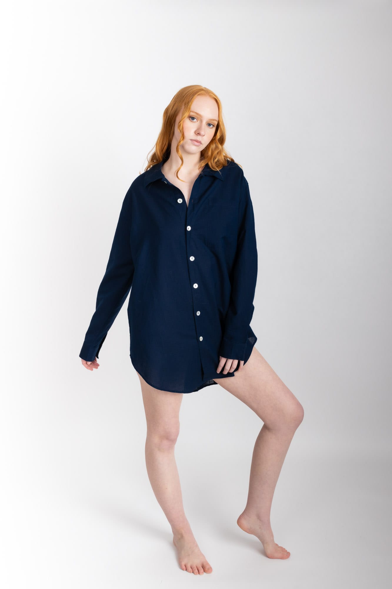 A classic man style shirt silhouette, lengthened, with a rounded hem and buttoned cuff. Featuring a single breast pocket, back box pleat and locker loop detail, and natural shell buttons.  In navy, and made from a blend of 55% organic cotton 45% linen, this shirt is finished with French seams.