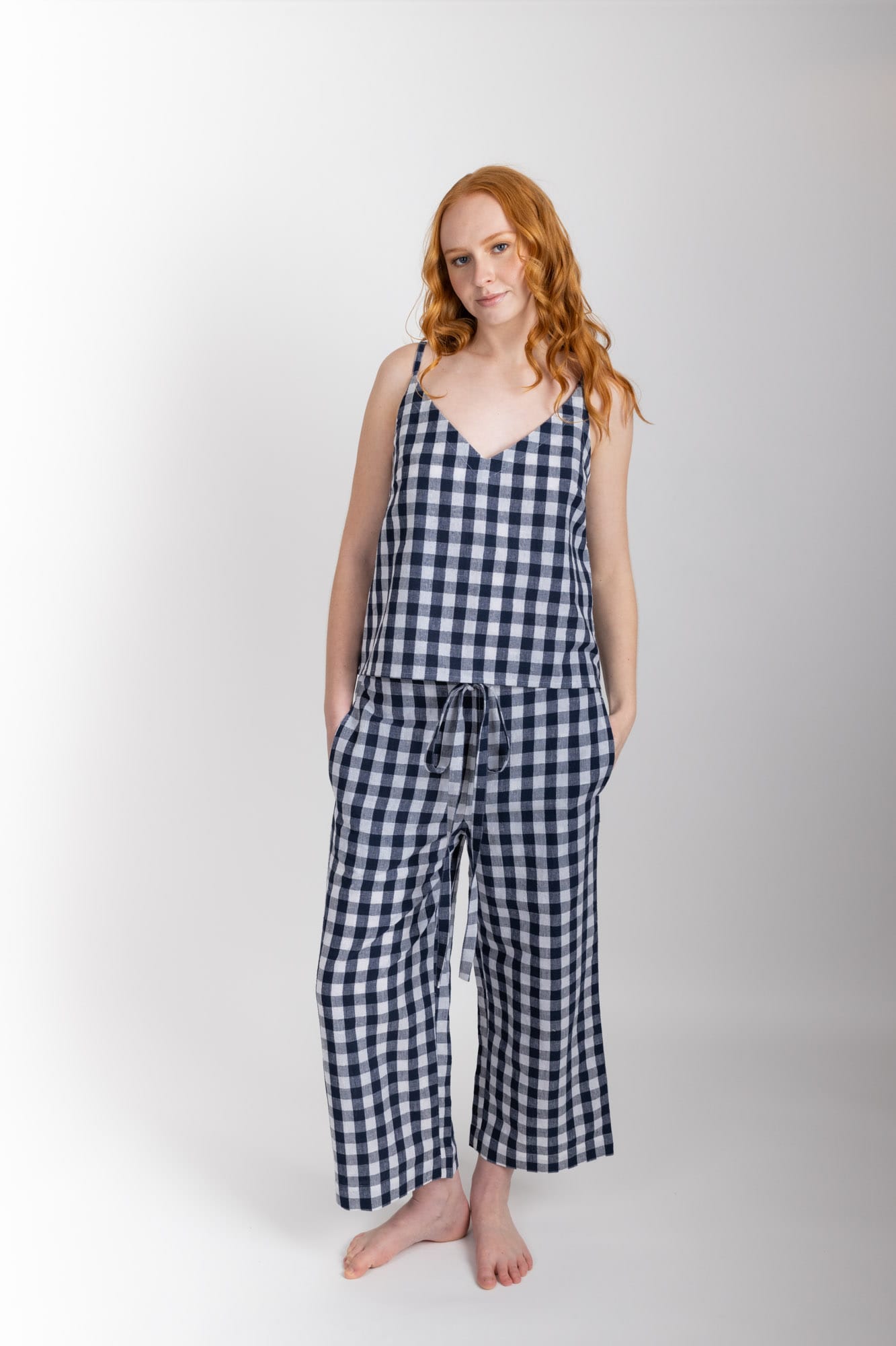 Women’s sleepwear set featuring a V-neck, swing-style camisole with adjustable straps. Paired with straight-leg cropped pant with an elasticated waist, flat front, and drawstring detail, these pants are comfortable and flattering. Woven in a blend of 55% organic cotton 45% linen, both pieces have been finished with French seams.